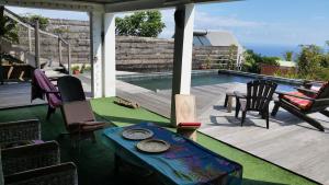a patio with a table and chairs next to a pool at Ty kaz plato in Saint-Leu