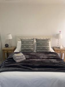 ein Bett mit zwei Kissen und zwei Tische mit Lampen in der Unterkunft Antonella's in Edenvale + 13 Fotos