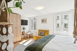 a bedroom with a bed and a yellow chair at Klara 1014 - Olma, Spital, Uni St- Gallen in St. Gallen