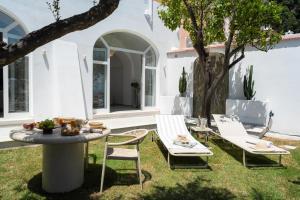 a patio with two chairs and a table and a tree at Casanova Suite in Positano
