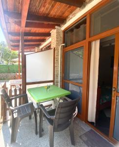 una mesa verde y sillas en un patio en At-Salaj3, en Vlorë