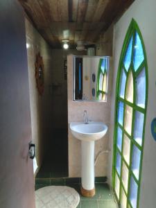 a bathroom with a sink and a stained glass window at Quarto duplo de frente para o mar, Casa da Jô in Angra dos Reis