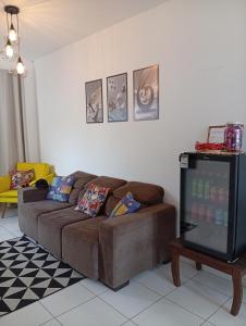 a living room with a brown couch and a tv at Casa de férias Pôr do Sol in Presidente Epitácio +33 photos