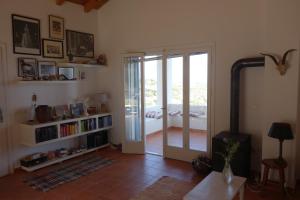 a living room with a door open to a patio at Eudaimonia in Vasilítsion