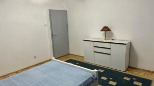 a room with a bed and a lamp on a dresser at Adria spa Rafailovici in Becici