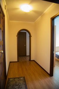 an empty hallway with an archway and a door at Apartment NG Na Chertygasheva in Abakan