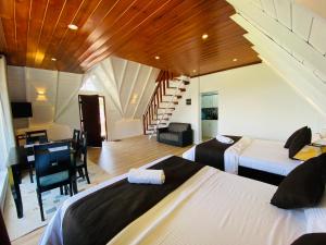 a bedroom with two beds and a desk and a staircase at Meridian Haven in Nuwara Eliya +38 photos