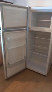 a white refrigerator with its door open and its shelves at Luketovi in Kostanjevica na Krasu