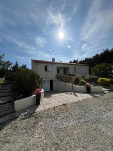 Una casa con dos macetas delante de ella. en Maison Familiale 6 pers - Orouët, en Saint-Jean-de-Monts