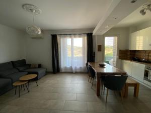 a living room with a couch and a table at Casamea - 2 chambres, Proche Hôpital, WiFi, Clim in Ajaccio
