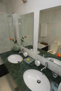 La salle de bains est pourvue de 2 lavabos et d'un grand miroir. dans l'établissement Quinta da Veiga, à Covas do Douro