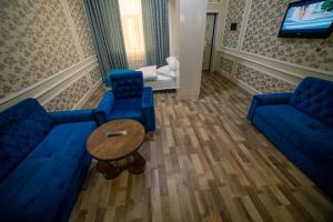 a living room with two blue couches and a table at Xan boutique hotel in Sheki