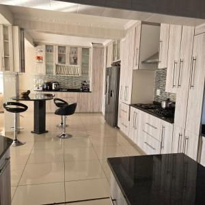 a kitchen with white cabinets and a black counter top at Cosy Villa in Stegi