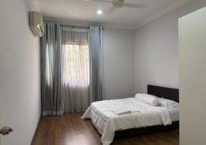 Una habitación blanca con una cama y una ventana en The Haven at Divina, Shah Alam, en Shah Alam