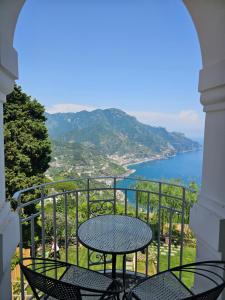 a table on a balcony with a view of the water at Blue Sunset in Ravello