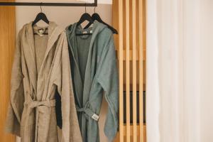 een paar jassen hangen aan een rek bij Capital Suites Skopelos in Neo Klima +68 foto's