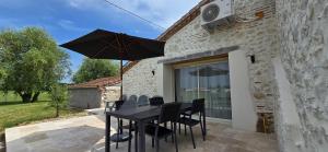un tavolo nero con sedie e ombrellone su un patio di La Maison Chehaa a Bias