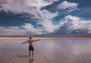 a man standing in a body of water at Desert Wings in San Pedro de Atacama