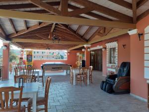 a patio with tables and chairs and a pool table at ILENIMA Hotels in Agios Stefanos