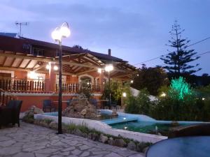 a house with a swimming pool at night at ILENIMA Hotels in Agios Stefanos