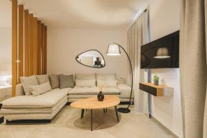 een woonkamer met een bank en een tafel bij Capital Suites Skopelos in Neo Klima