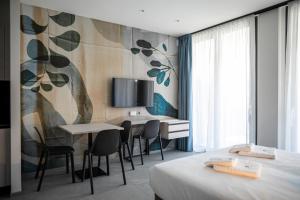 een hotelkamer met een bed, een tafel en stoelen bij Residence Diana in Bibione