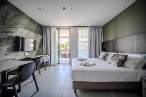 a hotel room with a bed and a table and chairs at Residence Diana Seafront in Bibione +291 photos