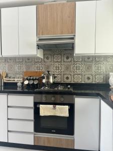 a kitchen with white cabinets and a stove top oven at Colina Smir in Marina Smir
