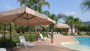 a group of chairs and umbrellas next to a pool at Relais San Giovanni srls in Castellaneta
