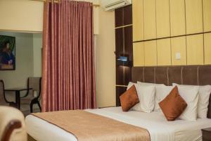 Ένα ή περισσότερα κρεβάτια σε δωμάτιο στο Forever Hotel and Suites