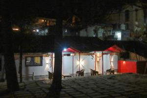 卡绍利Heritage homestays的享有带椅子和灯的建筑的夜景