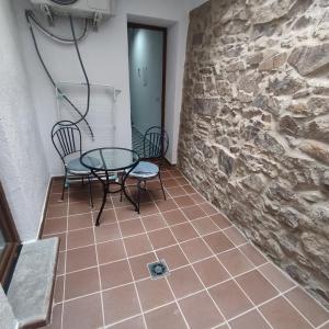 Una habitación con una mesa y sillas y una pared de piedra. en Estudio en Blanes, en Blanes 1 foto más