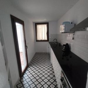 Una cocina con suelo de baldosas blancas y negras. en Estudio en Blanes, en Blanes