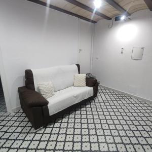 un sofá sentado en una habitación con una pared blanca en Estudio en Blanes, en Blanes
