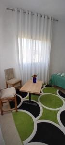 une pièce avec un tapis vert et blanc avec une table dans l'établissement Elira House, à Rrashbull