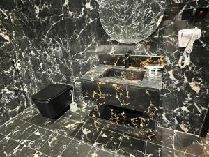 een zwart marmeren badkamer met een wastafel en een spiegel bij الجوهرة بارك 1 in Riyad +9 foto's