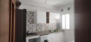 a kitchen with white cabinets and a sink and a window at S 3 a AFH Mrezga Hammamet in Hammamet Nord +3 photos
