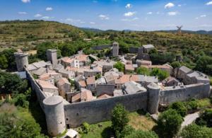 an aerial view of a village with a castle at Maison cévenole Alzon in Alzon