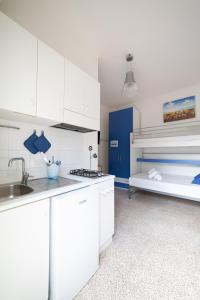 a kitchen with white cabinets and a bunk bed at Vivilo Collection - Santa Laura Loft with Garden in Sperlonga