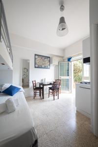 a bedroom with a bed and a table and chairs at Vivilo Collection - Santa Laura Loft with Garden in Sperlonga +11 photos