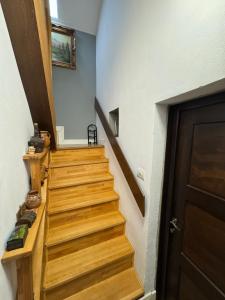 a hallway with wooden stairs and a door at Lola's Apartment in Arad