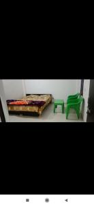 a room with a bed and a green chair at Kashi Villa Fully AC Rooms in Varanasi