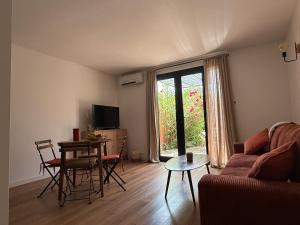 a living room with a couch and a table at Petite maison cocooning classée 3 étoiles à Bormes les mimosas in Bormes-les-Mimosas