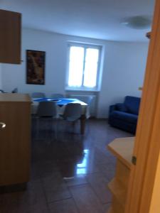 a living room with a table and a blue couch at Moderno appartamento e ampio garage in centro in Folgaria
