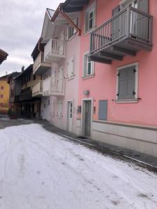 an empty street in front of a pink building at Moderno appartamento e ampio garage in centro in Folgaria