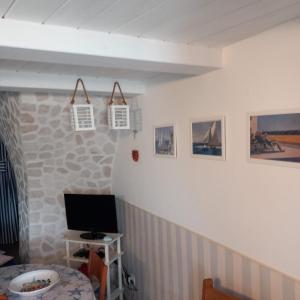 a room with a tv and some pictures on the wall at Borghetto Sul Mare in Peschici +37 photos