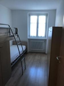 a small room with a bunk bed and a window at Moderno appartamento e ampio garage in centro in Folgaria