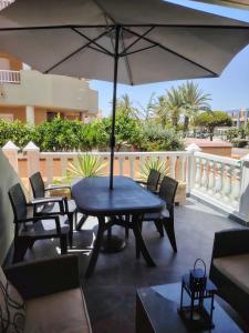 a patio with a table and chairs and an umbrella at Chalet entre dos mares. in San Blas