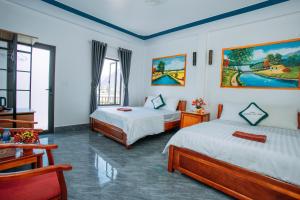 a hotel room with two beds and a window at Green Riverside Cosy Home 2 in Bố Trạch +65 photos