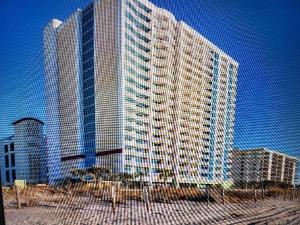 un edificio alto en una ciudad con una valla en Towers On The Grove, en Myrtle Beach